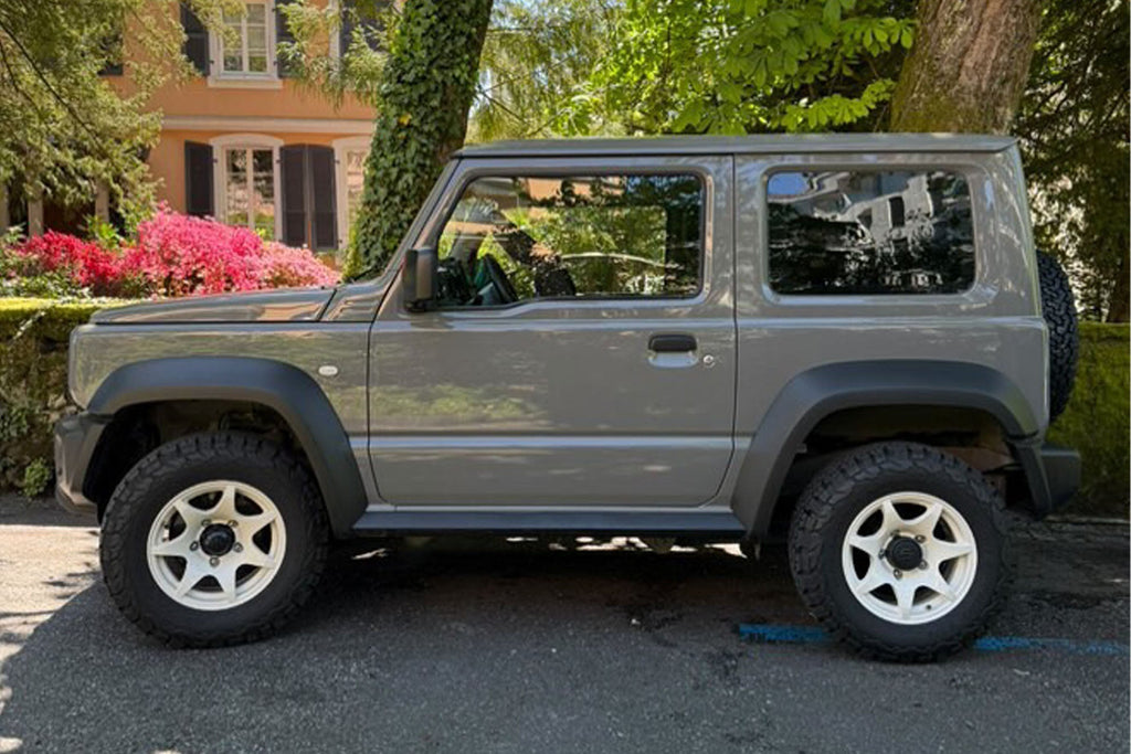 Grey Suzuki Jimny (2018+) fitted with Vintage White High Peak J-02 Wheels